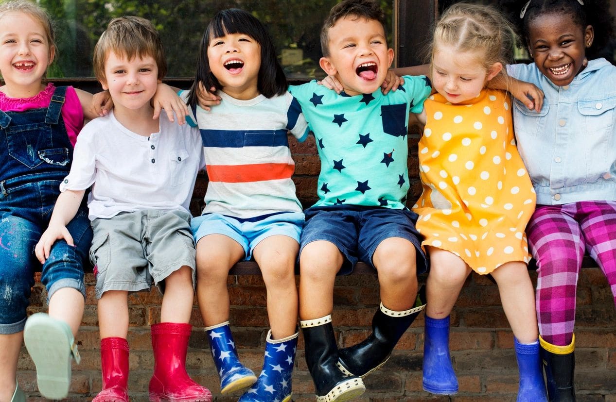 A group of children sitting on the ground together.